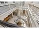 A beautiful spiral staircase descends into a grand foyer with elegant columns and ornate iron railings at 1067 Westway Dr, Sarasota, FL 34236