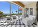 A bright sunroom features floor-to-ceiling windows and checkered tile overlooking the ocean at 1067 Westway Dr, Sarasota, FL 34236