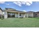 Expansive backyard with lush green lawn and covered patio, perfect for outdoor living at 12719 Sunbridge Dr, Venice, FL 34293