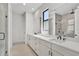 Modern bathroom features double sinks, large mirrors, and a glass-enclosed shower, creating a luxurious space at 12719 Sunbridge Dr, Venice, FL 34293