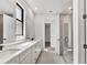 Bright bathroom featuring double sinks, a spacious countertop, and a glass-enclosed shower, offering a spa-like experience at 12719 Sunbridge Dr, Venice, FL 34293