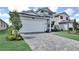 Modern two-story home with a two-car garage and a paved driveway, surrounded by manicured landscaping at 12719 Sunbridge Dr, Venice, FL 34293