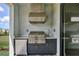Outdoor kitchen featuring grill, refrigerator, sink, and ample counter space at 12719 Sunbridge Dr, Venice, FL 34293