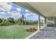 Covered patio with outdoor kitchen overlooking a lush, landscaped backyard at 12719 Sunbridge Dr, Venice, FL 34293