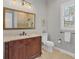 Well-lit bathroom with a dark wood vanity, marble countertop, and tiled shower with glass door at 16009 Clearlake Ave, Lakewood Ranch, FL 34202