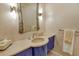 Powder room with a vessel sink, custom mirror, unique sconces, and striking blue cabinetry at 435 L Ambiance Dr # L807, Longboat Key, FL 34228
