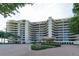 Upscale condo complex with rounded balconies and meticulously manicured landscaping and circular brick driveway at 435 L Ambiance Dr # L807, Longboat Key, FL 34228