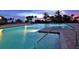 Beautiful pool at dusk with palm trees and lounge chairs at 435 L Ambiance Dr # L807, Longboat Key, FL 34228