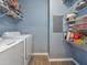 Laundry room with white washer and dryer, and wire shelving with supplies and accessories at 4802 51St W St # 1811, Bradenton, FL 34210