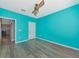 An empty bedroom with blue walls, hard wood floors, and a door at 4802 51St W St # 1811, Bradenton, FL 34210