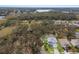 Expansive aerial view of a two-story home surrounded by mature trees, a lush lawn, and a pond in the distance at 5809 71St E St, Palmetto, FL 34221