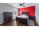 Cozy bedroom featuring wood floors, a vibrant red accent wall, and matching dark wood furniture at 5809 71St E St, Palmetto, FL 34221