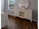 Elegant bedroom with wood floors, natural light, a white dresser, and a stylish round mirror at 5809 71St E St, Palmetto, FL 34221