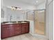 Bathroom with double vanity, granite countertop, and glass shower enclosure at 8079 36Th Street E Cir, Sarasota, FL 34243