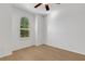 Inviting bedroom featuring a ceiling fan, hardwood flooring, and a large window providing plenty of natural light at 8079 36Th Street E Cir, Sarasota, FL 34243