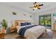 Staged main bedroom showcasing a king-sized bed and backyard view at 8079 36Th Street E Cir, Sarasota, FL 34243