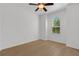 Bright bedroom with hardwood flooring, a ceiling fan, and a large window providing plenty of natural light at 8079 36Th Street E Cir, Sarasota, FL 34243