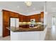 Well-lit kitchen featuring dark wood cabinets, granite countertops, and modern lighting at 8079 36Th Street E Cir, Sarasota, FL 34243
