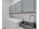 Well-equipped laundry room with upper cabinets, a modern sink, and a washer and dryer at 8079 36Th Street E Cir, Sarasota, FL 34243