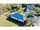 An aerial view of the home with manicured lawn, lush foliage, and a dark blue roof at 8134 Coates Row Pl, Bradenton, FL 34201