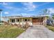 Inviting single-story home with a covered carport, a cozy front porch, and tidy landscaping at 1206 2Nd E Ave, Bradenton, FL 34208