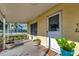 A home's covered front porch features a white door, large window and potted plants at 1206 2Nd E Ave, Bradenton, FL 34208