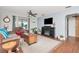 Comfortable living room with ceiling fan, fireplace, wood flooring, and neutral colored walls at 1206 2Nd E Ave, Bradenton, FL 34208