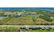 An aerial view of a backyard with a grassy lawn near a wooded edge and close to neighborhood ponds at 12750 Oak Hill Way, Parrish, FL 34219