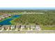 An aerial view shows a home near a lake and surrounded by green spaces in a vibrant community at 12750 Oak Hill Way, Parrish, FL 34219