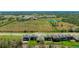 An aerial view of the backyard with a grassy lawn near a wooded edge and close to neighborhood ponds at 12750 Oak Hill Way, Parrish, FL 34219