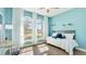 Bright bedroom featuring large windows, light wood floors, and fresh blue walls at 12750 Oak Hill Way, Parrish, FL 34219