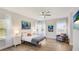 Sunlit bedroom features hardwood floors, cozy chair, and beach-themed artwork at 12750 Oak Hill Way, Parrish, FL 34219