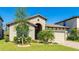 Charming single-story home featuring manicured landscaping and an attached two-car garage on a sunny day at 12750 Oak Hill Way, Parrish, FL 34219