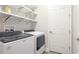 Laundry room with modern appliances, open shelving, and a white door at 12750 Oak Hill Way, Parrish, FL 34219