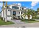 Elegant two-story home with meticulous landscaping, palm trees, and a paver driveway at 1525 Mallard Ln, Sarasota, FL 34239