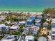 Aerial view of a seaside community, with lush vegetation, beachfront access, and turquoise ocean water at 2211 Avenue C, Bradenton Beach, FL 34217