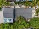 Aerial view of the home, showcasing its roof, private backyard patio, and lush landscaping at 2211 Avenue C, Bradenton Beach, FL 34217