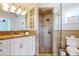 Bright bathroom with a granite countertop vanity and a tiled walk-in shower at 2211 Avenue C, Bradenton Beach, FL 34217