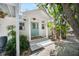 Charming front entry features a light blue door, white pillars, and tropical landscaping at 2211 Avenue C, Bradenton Beach, FL 34217