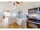 Open kitchen with white cabinetry, subway tile backsplash, stainless appliances, and a view to the living area at 2211 Avenue C, Bradenton Beach, FL 34217