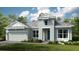 Charming one-story home with a blue front door, gray roof, a two-car garage, and beautifully landscaped front yard at 26902 Victoria Pl, Punta Gorda, FL 33955
