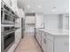 Close up on a kitchen featuring stainless appliances and a large center island with a sink at 26908 Victoria Pl, Punta Gorda, FL 33955