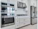 Modern kitchen featuring stainless steel appliances, white cabinetry, and stone countertops at 26908 Victoria Pl, Punta Gorda, FL 33955