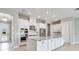 Bright open concept kitchen with white cabinetry, stainless appliances, and a large kitchen island at 26908 Victoria Pl, Punta Gorda, FL 33955