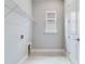 Practical laundry room featuring overhead shelving, neutral paint, and bright natural light at 26908 Victoria Pl, Punta Gorda, FL 33955