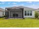 Exterior view of the house featuring a screened-in lanai and manicured lawn at 26930 Lark Ct, Punta Gorda, FL 33955