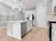 Kitchen island with stainless steel appliances, white cabinets, quartz countertops, and an open floor plan at 26930 Lark Ct, Punta Gorda, FL 33955
