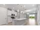 Open-concept kitchen with large island, modern appliances, white cabinets, and adjoining living area with bright natural light at 26930 Lark Ct, Punta Gorda, FL 33955