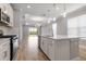 Beautiful kitchen with stainless steel appliances, island, white cabinets, and views of the backyard and adjacent living space at 26930 Lark Ct, Punta Gorda, FL 33955