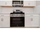 Close-up of a modern stainless steel range and microwave, complemented by sleek white cabinetry and countertops at 26930 Lark Ct, Punta Gorda, FL 33955